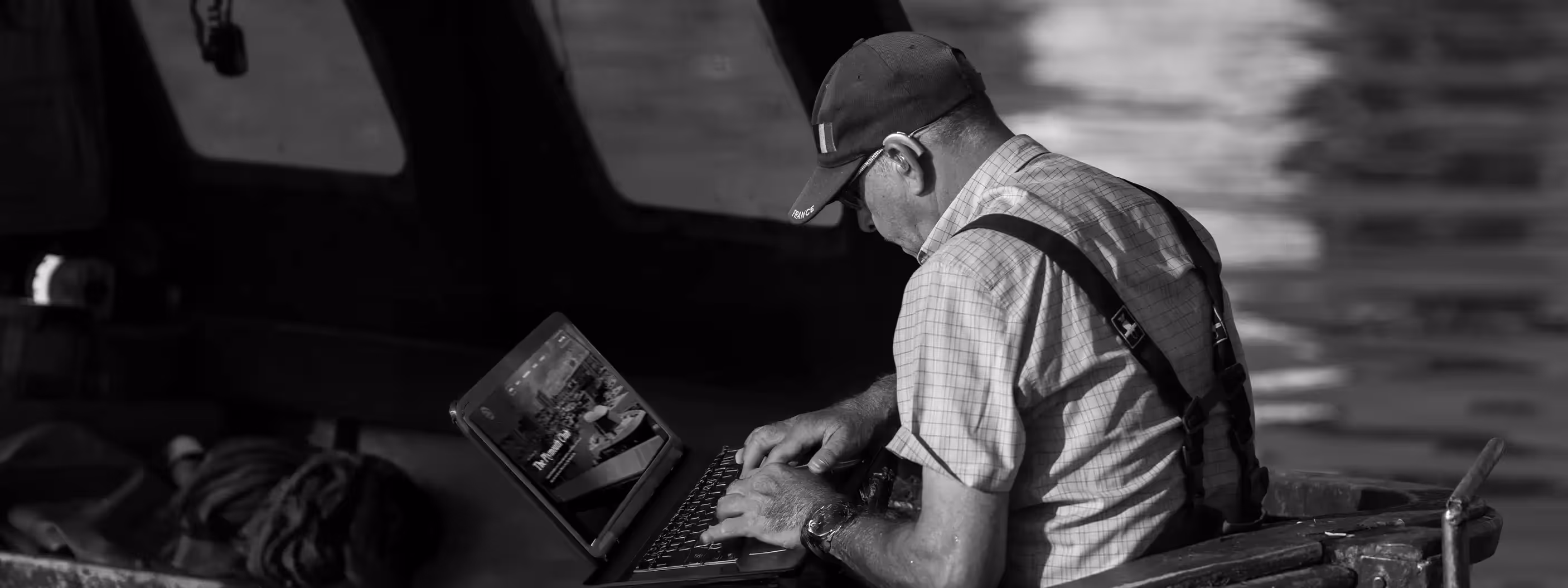 A business owner sitting on a boat, on his laptop, looking for local website services