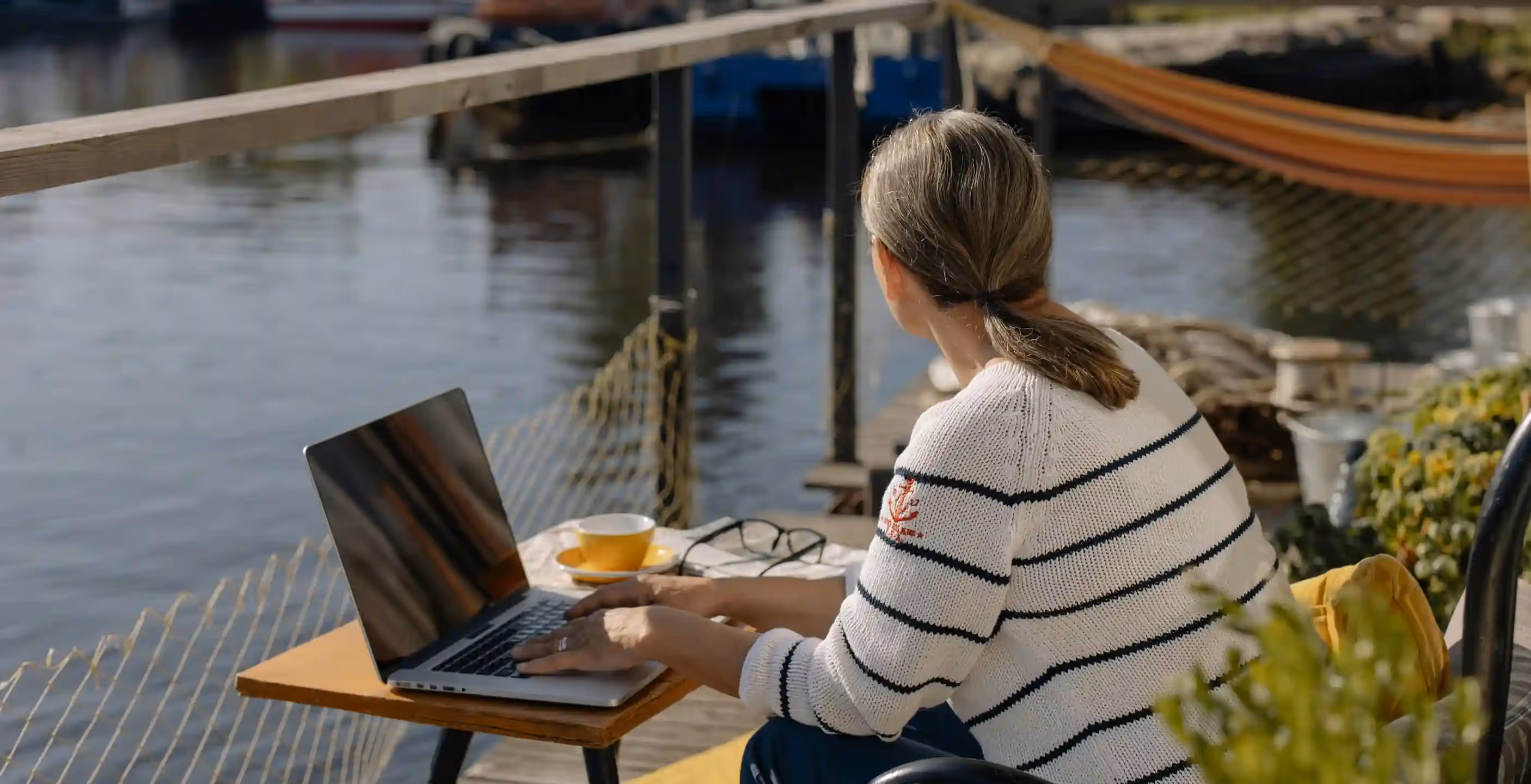A woman sitting at a table on the water in Kingston, MA, looking for local website design and development services