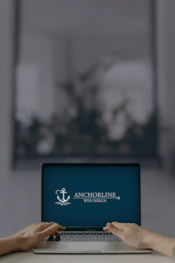 A person on a laptop, navingating to the Anchorline Web Design blog page.