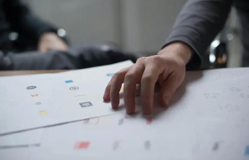 A person's hand over multiple professional print ads.
